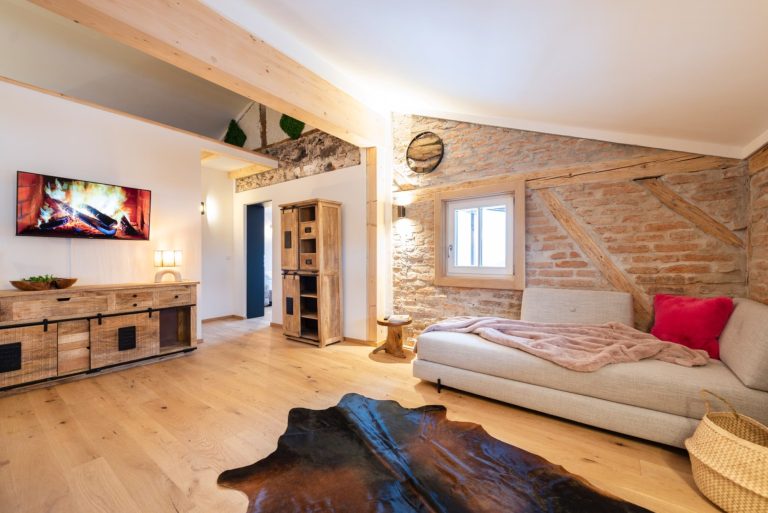Ein heller, modern und gemütlich eingerichteter Essbereich mit einem runden Holztisch in der Mitte.